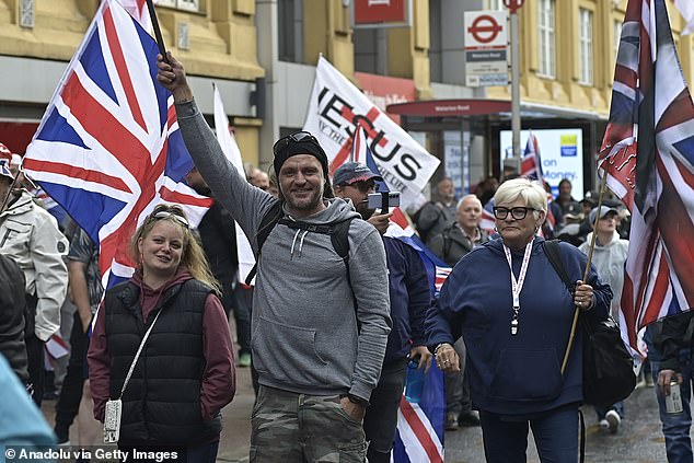 People carrying flags and banners gather at Stamford Street ahead of a march on Whitehall