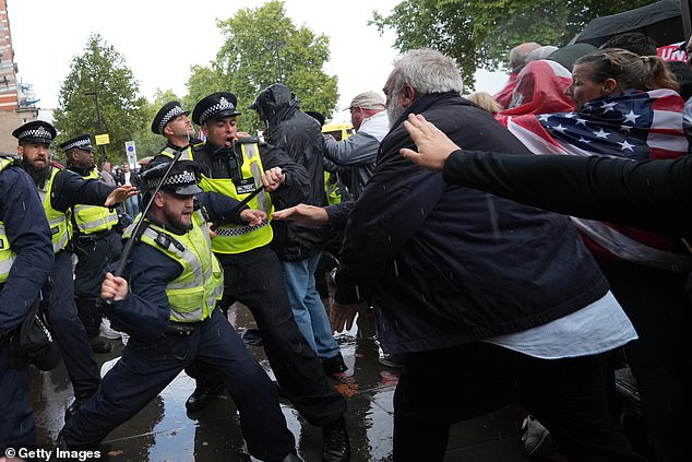 Police officers scuffle with protesters at the Unite The Kingdom march