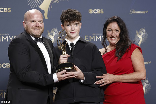 Owen proudly held up his shiny new trophy while joined by his parents in the press room