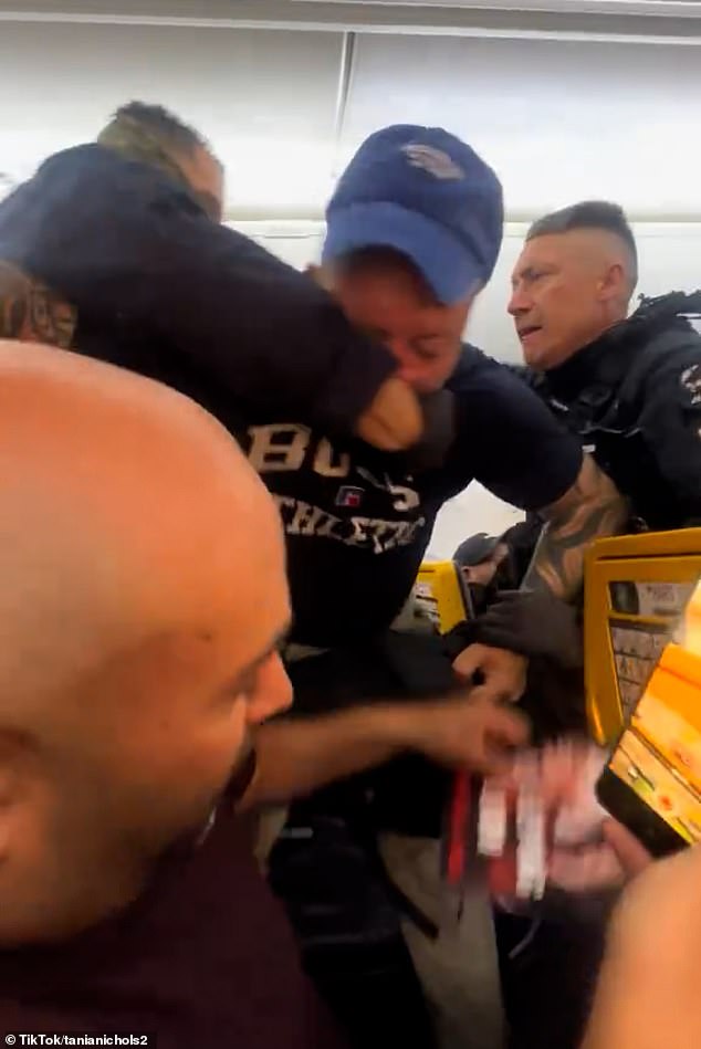 A violet struggle broke out between one of the drunk passengers and officers as they battled to restrain him, but the altercation spilled into the next row of seats as he attempted to break free