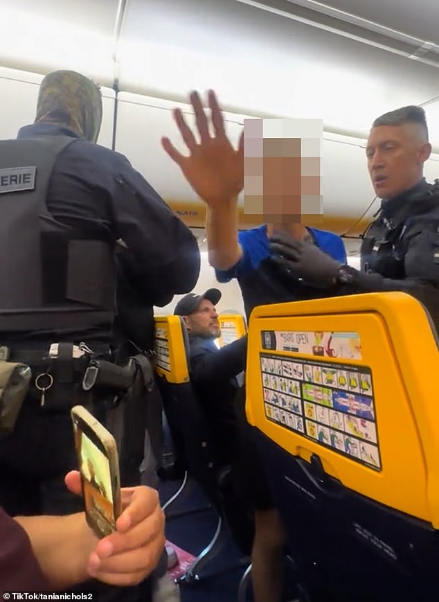 The police officer became embroiled in a verbal altercation as the arrested man's son stands up and tells the cops: 'He didn't start that, they started it, my dad did not start that'