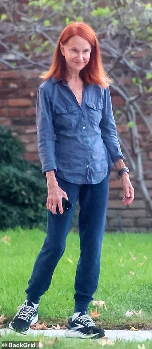 She flaunted her svelte figure in a gray¿blue button-up long-sleeve top with breast pockets, which she dressed down with navy sweatpants