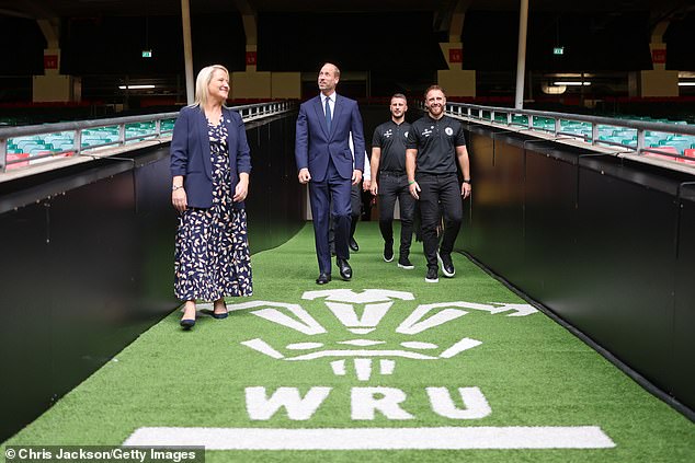 Prince William walks with Jac Lewis Foundation chief executive Elizabeth Thomas-Evans (left), Jac's father Jesse Lewis (third left) and teammates from Jac's football team Ammanford FC during his visit to new a mental health hub at Principality Stadium in Cardiff this afternoon