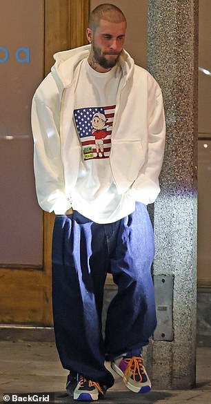 He kept it casual while sporting a printed white shirt as well as a white hooded sweatshirt that was unzipped at the front