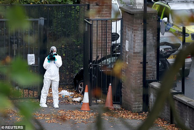 A forensic technician gathers evidence at the scene following the stabbing and car attack