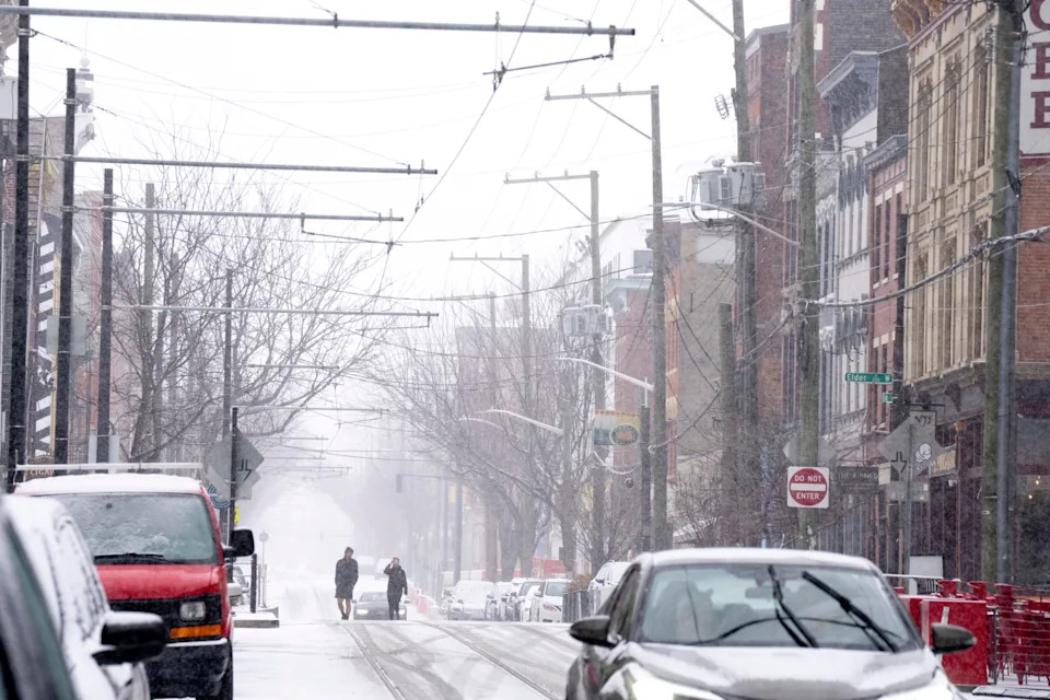 A pedestrian walks through snow in Over-The-Rhine in January.