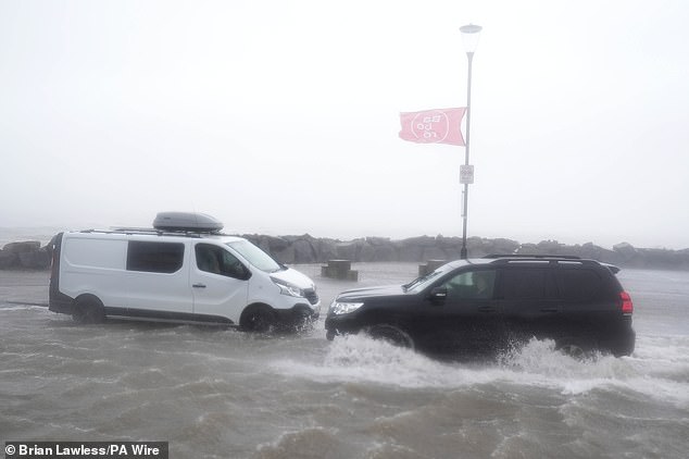 Cars attempt to drive through floodwaters in Galway, in the west of Ireland