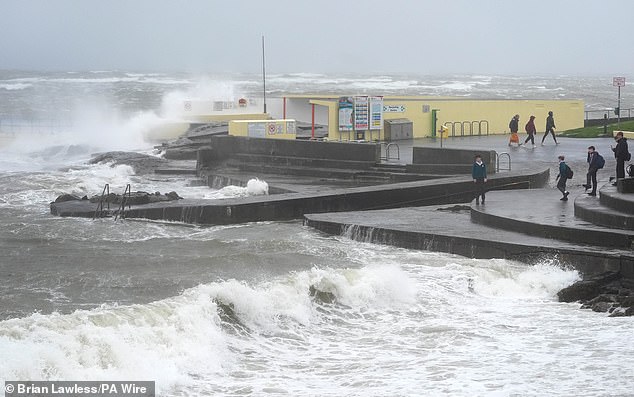 People at Blackrock diving tower in Salthill, Galway, on Friday as Storm Amy hit the UK