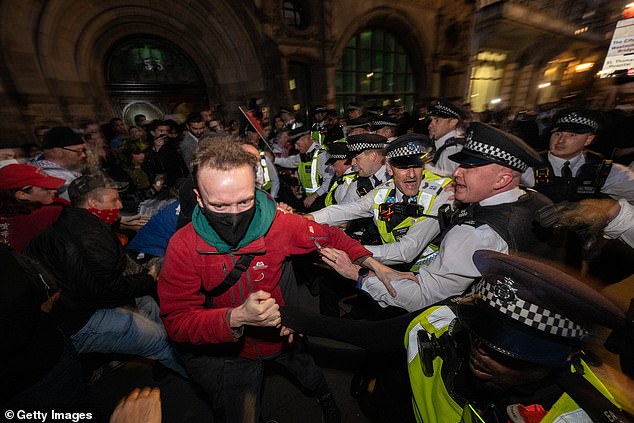Met Police officers faced off with protesters, some of whom wore face masks and scarves, outside Westminster on Thursday