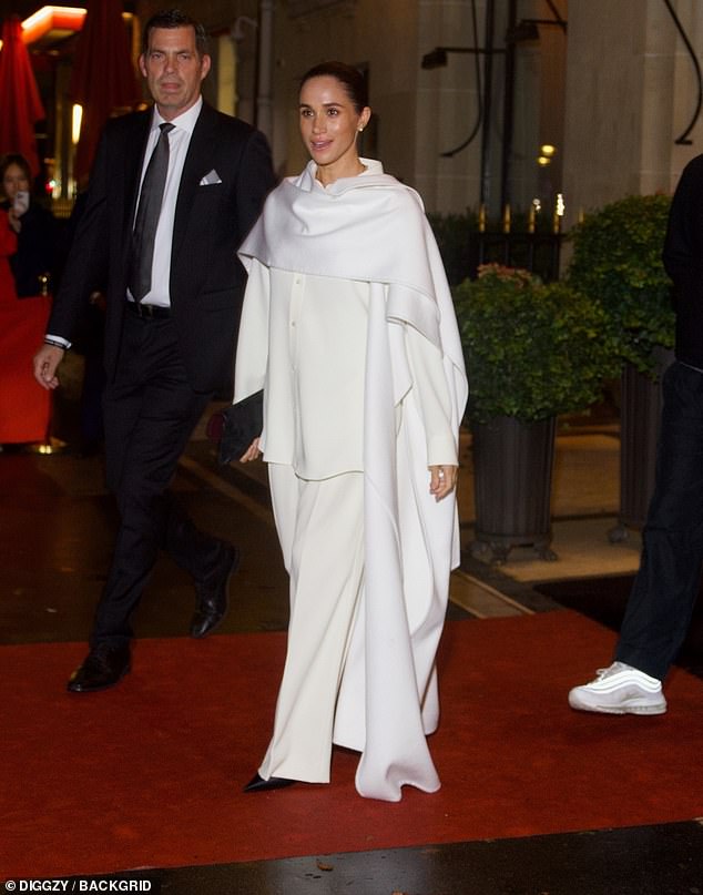 Prince Harry was nowhere to be seen as his wife was flanked by security who escorted her to a waiting car