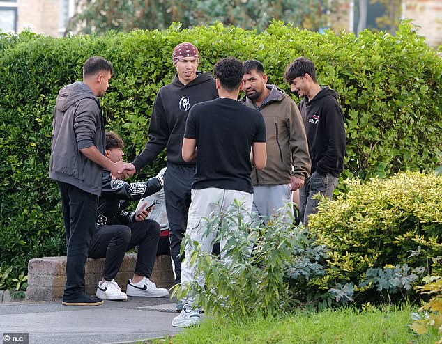 Asylum seekers loiter outside the Roundhouse Hotel, one of three migrant hotels in Bournemouth