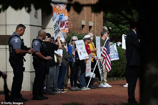ALEXANDRIA, VIRGINIA - OCTOBER 08: Activists protest outside the U.S. District Court for the Eastern District of Virginia's Bryan Courthouse ahead of the arraignment of former FBI Director James Comey on October 08, 2025 in Alexandria, Virginia. Comey will be arraigned today after being indicted by a Virginia grand jury on charges of making a false statement and obstruction during congressional testimony in 2020. (Photo by Win McNamee/Getty Images)