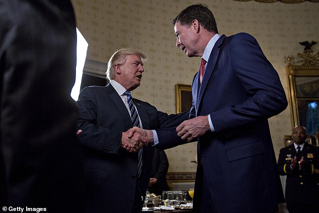 WASHINGTON, DC - JANUARY 22: U.S. President Donald Trump (C) shakes hands with James Comey, director of the Federal Bureau of Investigation (FBI), during an Inaugural Law Enforcement Officers and First Responders Reception in the Blue Room of the White House on January 22, 2017 in Washington, DC. Trump today mocked protesters who gathered for large demonstrations across the U.S. and the world on Saturday to signal discontent with his leadership, but later offered a more conciliatory tone, saying he recognized such marches as a "hallmark of our democracy." (Photo by Andrew Harrer-Pool/Getty Images)