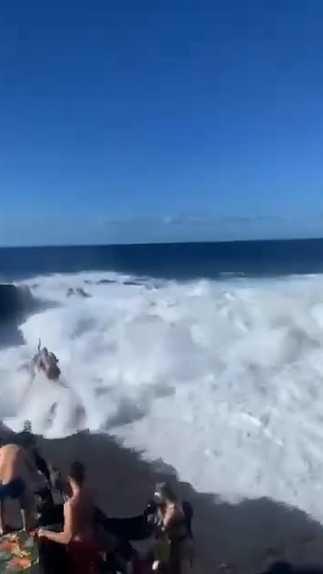 The wave slammed into several people, knocking them over