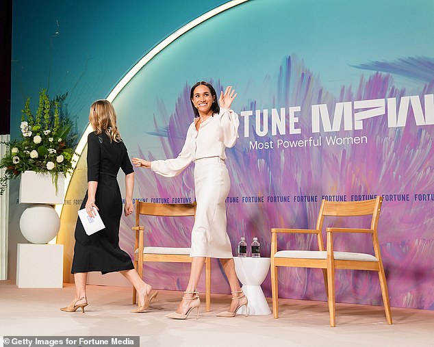 Meghan waves as she walks off stage alongside Alyson Shontell from Fortune yesterday