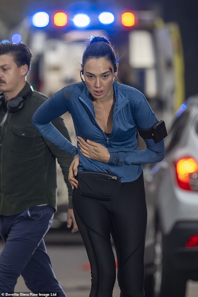 The Israeli film star was pictured running in black sports leggings and a blue zip-up top for the night-time shoot through the city's streets
