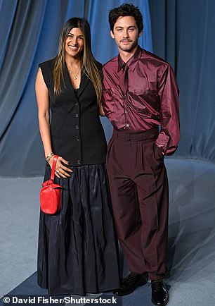 Logan Lerman donned a dark purple shirt and trousers as he attended the event alongside another guest