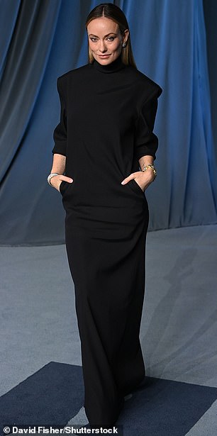 Olivia Wilde wore a long-sleeved black dress with pockets and allowed her hair to flow down straight behind her