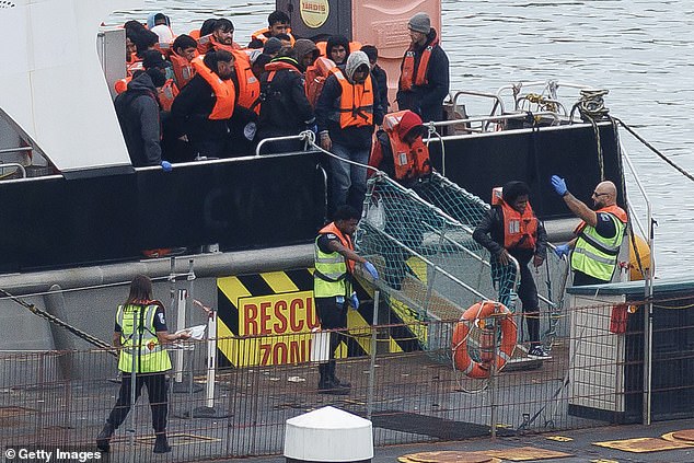 Kebatu sexually assaulted the schoolgirl just eight days after arriving on a small boat (Pictured: Asylum seekers are brought ashore in Dover on October 8)