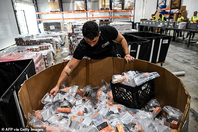 Volunteers assemble relief packages for Hurricane Melissa at the Global Empowerment Mission headquarters in Miami, Florida, on October 27