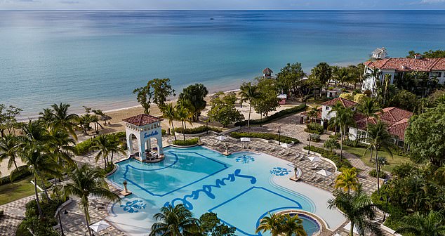 Aerial view of Sandals South Coast luxury resort with pool, beach, villas, and lush greenery in Whitehouse, Jamaica.