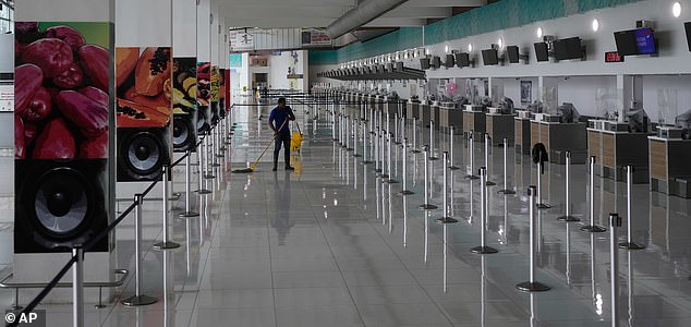A janitor mops the floor at Norman Manley International Airport, closed ahead of the forecast arrival of Hurricane Melissa, in Kingston, Jamaica, Sunday, Oct. 26, 2025. (AP Photo/Matias Delacroix)
