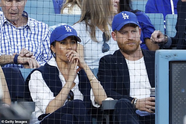 Koufax (L) checks his watch in his second-row seat behind Harry and Meghan at the Dodgers