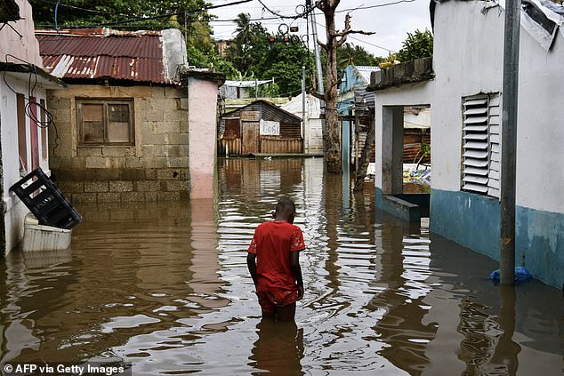 TOPSHOT - A man walks along a flooded street after the passing of the tropical storm Melissa before becoming a hurricane at Las Cucarachas neighborhood in Santo Domingo, Dominican Republic on October 28, 2025. (Photo by Danny Polanco / AFP) (Photo by DANNY POLANCO/AFP via Getty Images)