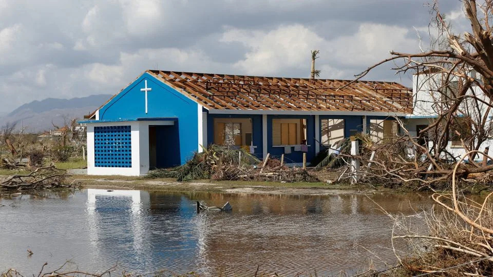 A building stands amid torn tree branches and flooding on Thursday. - Octavio Jones/Reuters