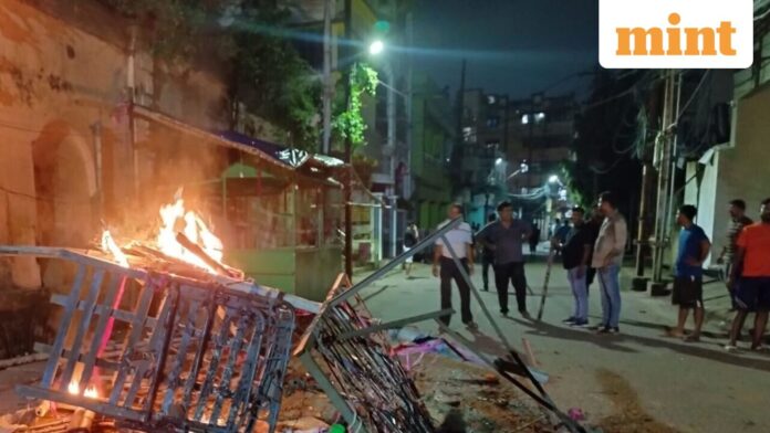 Cuttack tense after clashes: 36-hour curfew, internet shutdown; 60 platoons People gather near objects set ablaze after fresh incidents of violence linked to a group clash two days ago during a Durga idol immersion procession, in Cuttack, Odisha, Sunday, Oct. 5, 2025.