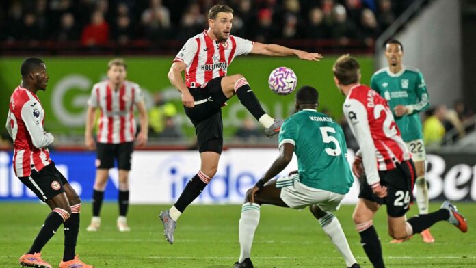 Brentford's English midfielder #06 Jordan Henderson (C) jumps for the ball during the English Premier League football match between Brentford and Liverpool at the Gtech Community Stadium in London.