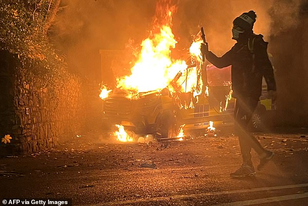 Migrant, 26, whose arrest over sexual assault of 10-year-old Irish A migrant who allegedly sexually assaulted a 10-year-old girl outside an asylum seeker hotel in Dublin was awaiting deportation (pictured: Riots on Tuesday night)