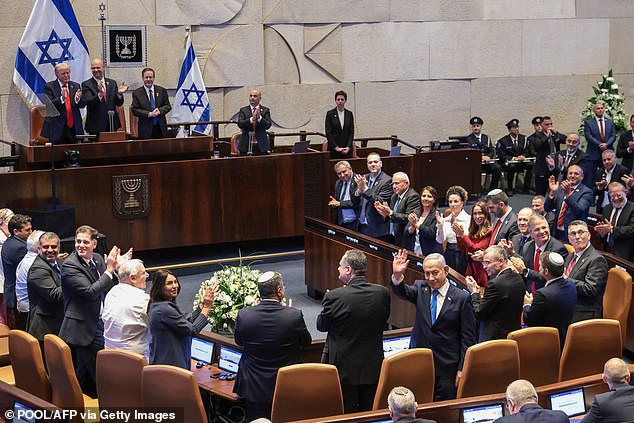Israeli Prime Minister Benjamin Netanyahu (center right) gestures as he is applauded before an address by US President Donald Trump (top left) at the Israeli parliament, the Knesset, in Jerusalem on October 13, 2025