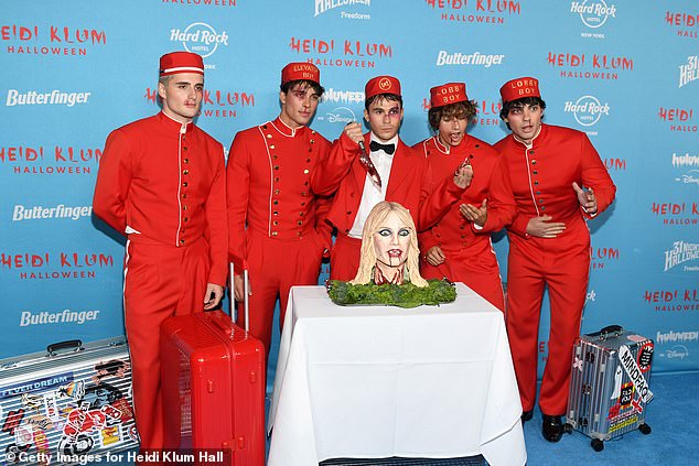 Elevator boys Luis Freitag, Tim Schaecker, Julien Brown, Bene Schulz and Jacob Rott dressed as 'lobby boys,' in matching red costumes, and even brought along their own cake shaped like Heidi Klum on a table, as Schulz held a knife over it