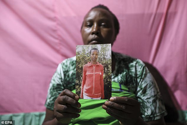 Pictured: Rose Wanyua, the sister of Agnes Wanjiru, shows journalists pictures of her late sister inside her house in Majengo Slums in Nanyuki