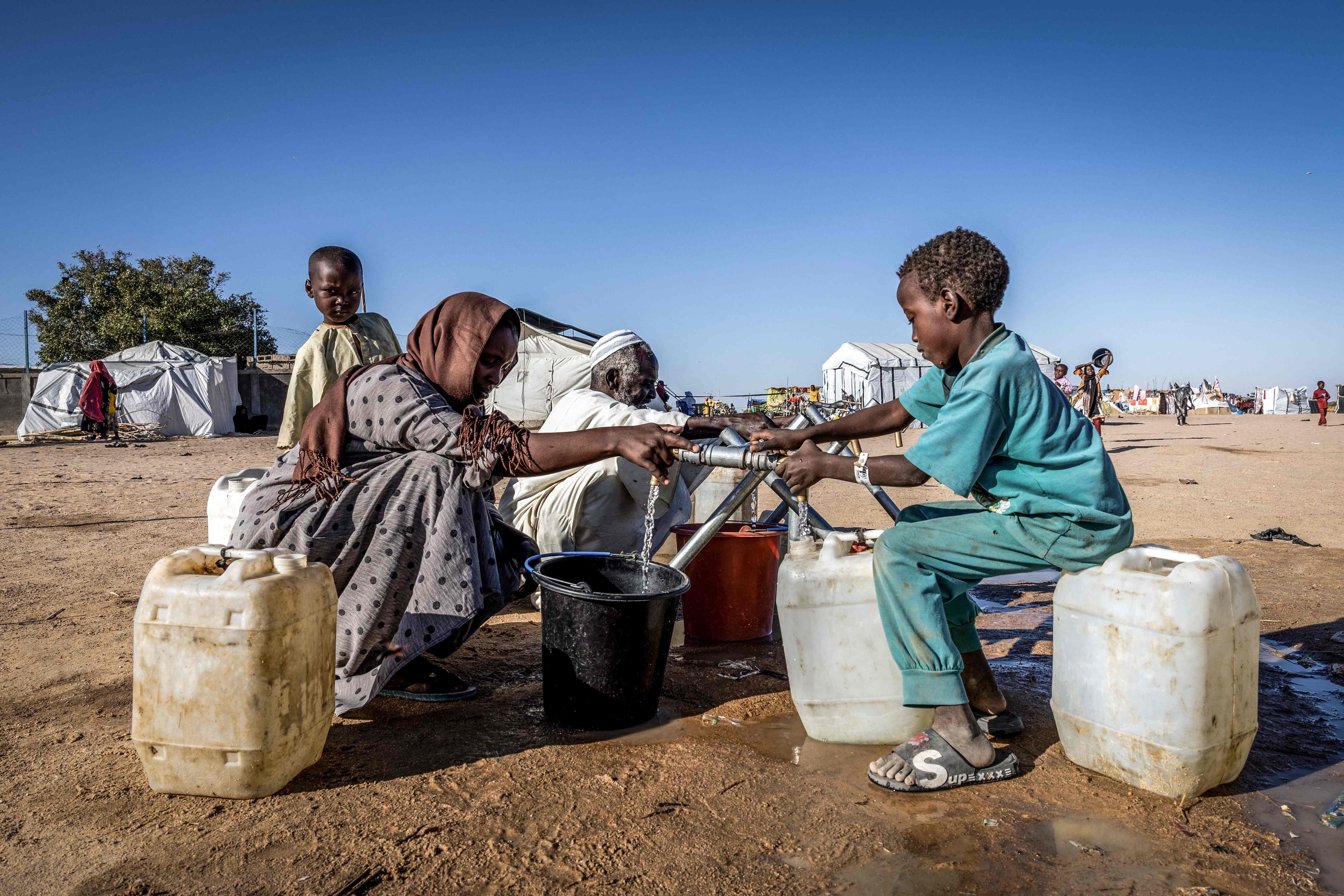 Sudanese refugees fill water containers at a water point in the Tine transit camp in Chad.(AFP) Sudanese refugees fill water containers at a water point in the Tine transit camp in Chad.(AFP)
