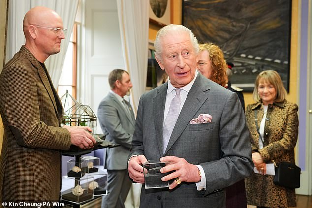 The King holds a fossil during a visit to Cyfarthfa Castle in Merthyr Tydfil, South Wales, for a celebratory reception marking the Castle's 200th anniversary and the King's 77th birthday