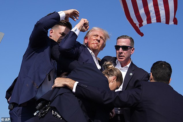 Trump raises his fist after Crooks's assassination attempt at a Pennsylvania rally in 2024