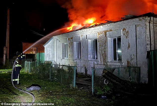 A firefighter tends to a fire in a residential building in Semenivka, Chernihiv region