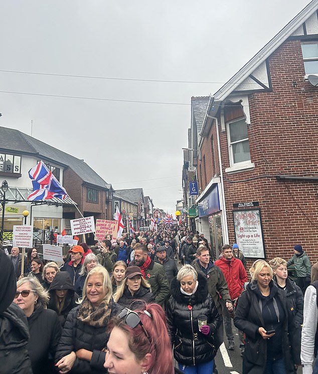 Locals walk through the town with their children to demand the Labour government drops its plan to use the army camp for male asylum seekers