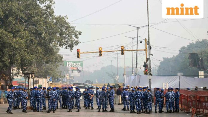 Rapid action force personnel stand guard near the blast site, after an explosion in the Red Fort area in the old quarters of Delhi, on November 12, 2025. 