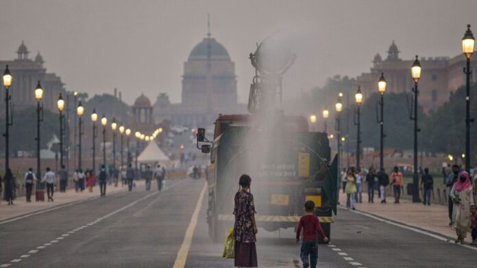 Delhi’s air quality stays ‘very poor’ — will it worsen New Delhi: Children look on as an anti-smog gun sprays water along the Kartavya path overlooking the Rashtrapati Bhavan, in New Delhi, Friday, Oct. 24.