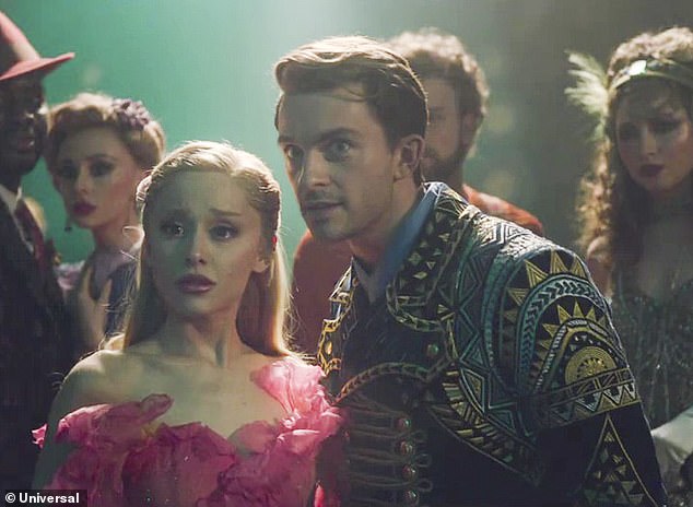 He portrays the love-interest to Ariana Grande 's character Glinda and has an interesting possibly romantic dynamic with Cynthia Erivo 's Elphaba